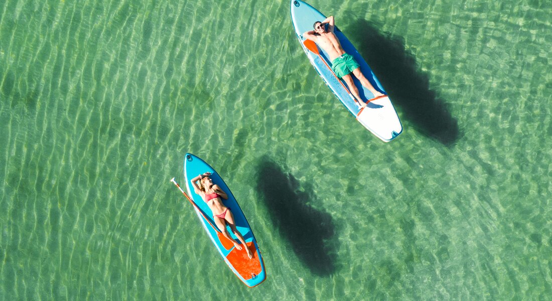 Due ragazzi in sup sulle acque cristalline del Biolago