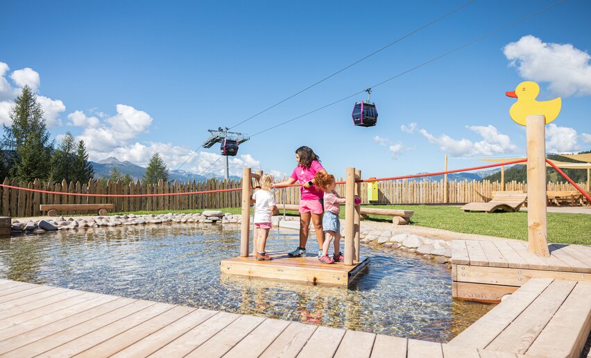 Tre bambine sulla zattera del laghetto al parco Giro d'Ali | © APT Fiemme e Cembra - Gaia Panozzo