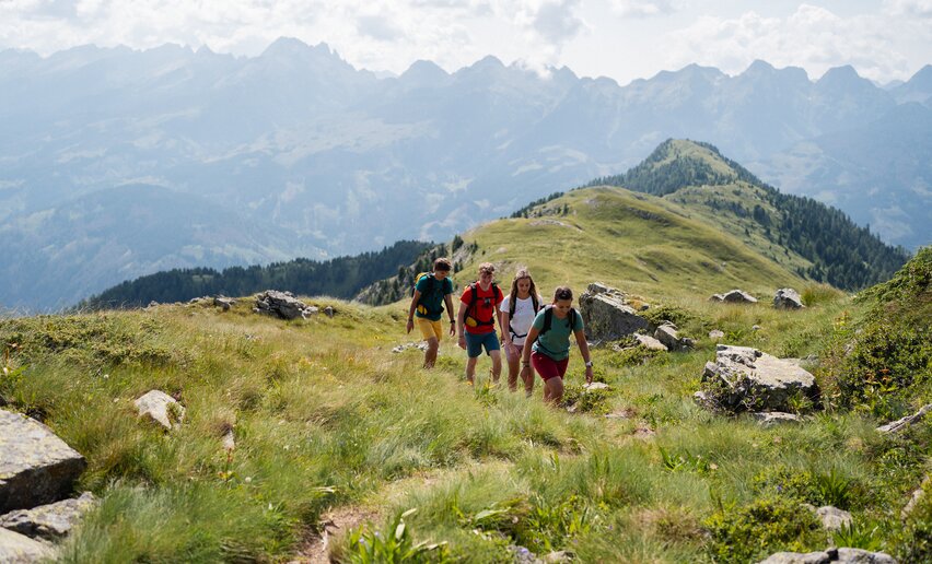 Amici in escursione percorrono un sentiero a Pampeago | © APT Fiemme e Cembra - Alice Russolo