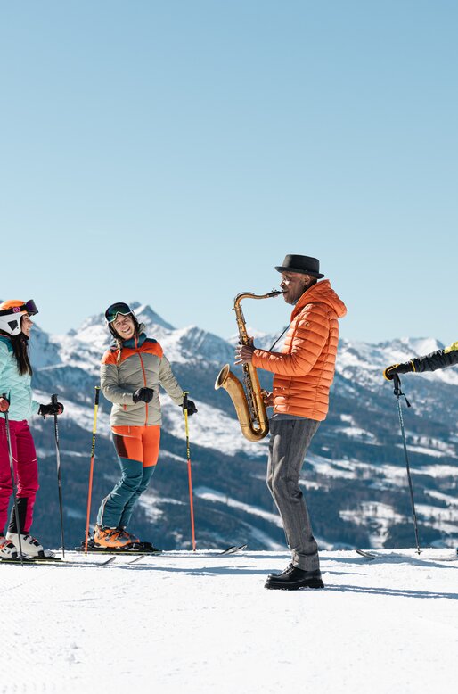 James Thompson suona il sax per degli sciatori | © APT Fiemme e Cembra - Gaia Panozzo