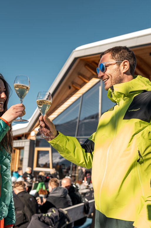 Coppia si gode un calice di bollicine sulla terrazza soleggiata dello Chalet all'Alpe Cermis | © APT Fiemme e Cembra - Mattia Rizzi